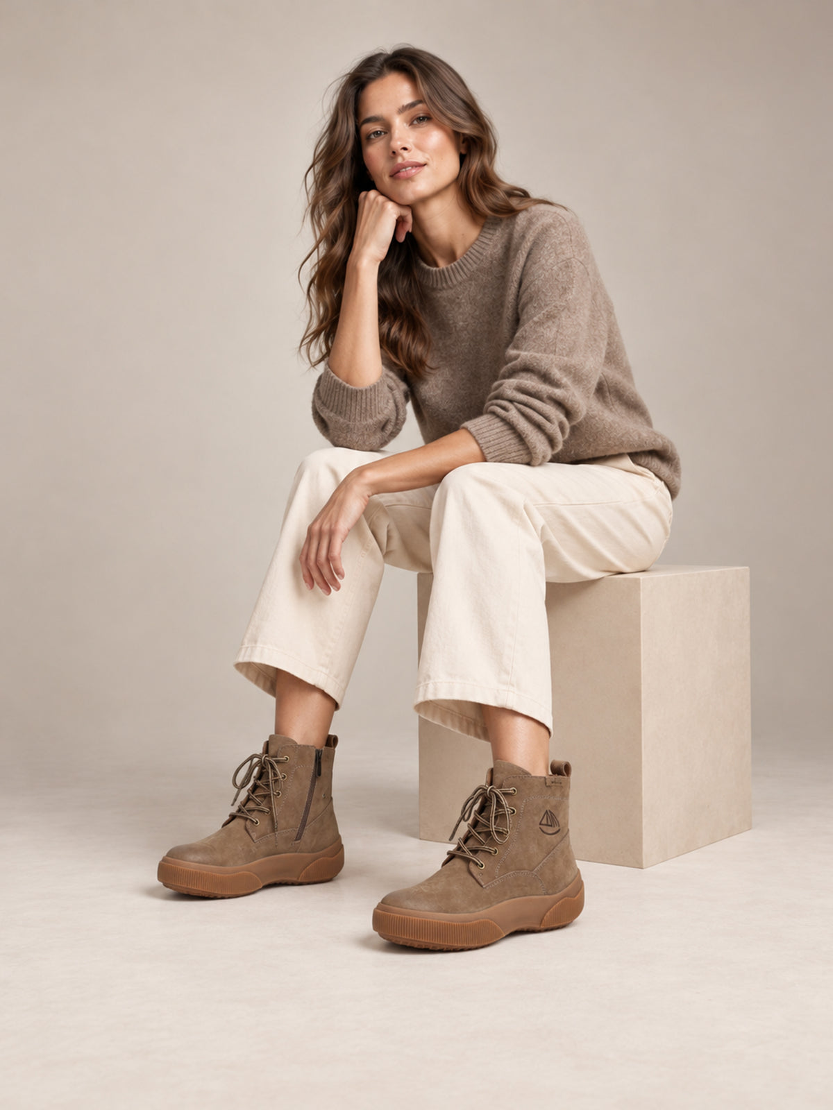 Brown Yaoyao sole ankle boots, worn in a seated outfit.