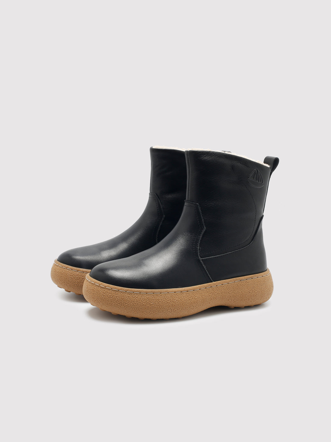 Black polished winter boots with tan soles, pair viewed from the front at an angle.