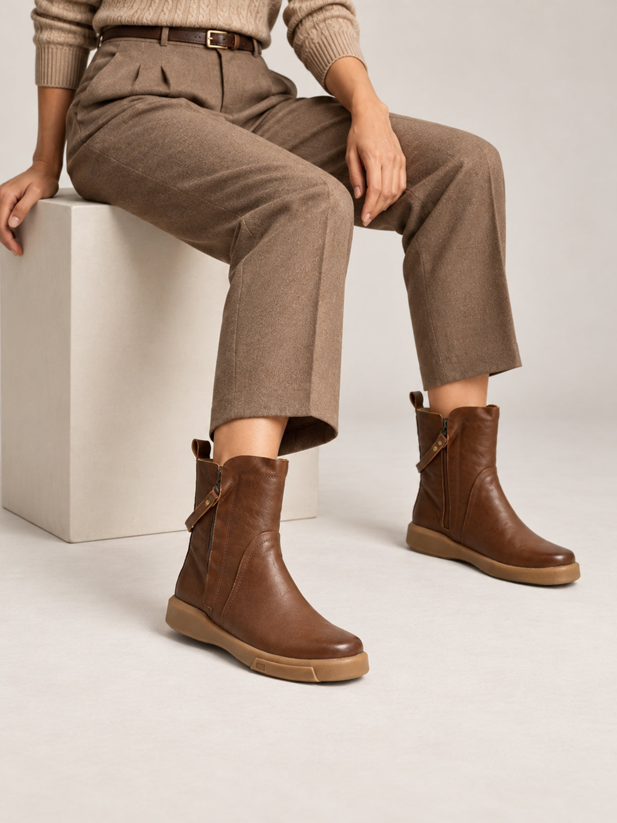 Brown double-zip leather boots, close-up of the boots worn with cropped brown trousers.