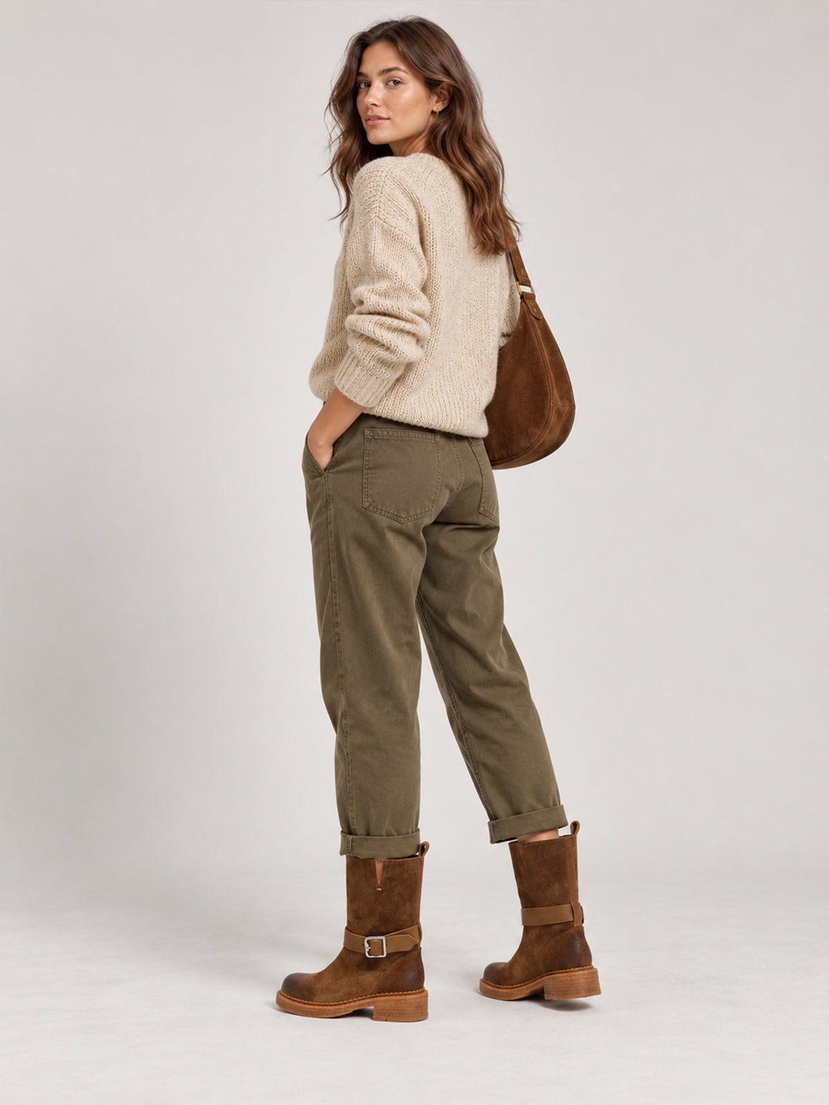 Brown Spanish-inspired buckle boots, worn with a cream sweater and olive trousers.