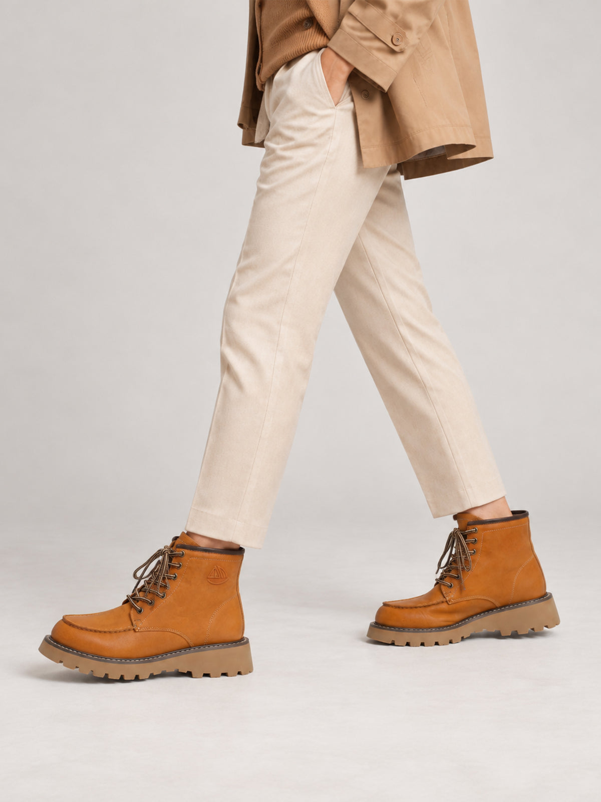 Tan washed leather combat boots, close-up of the shoes being worn.
