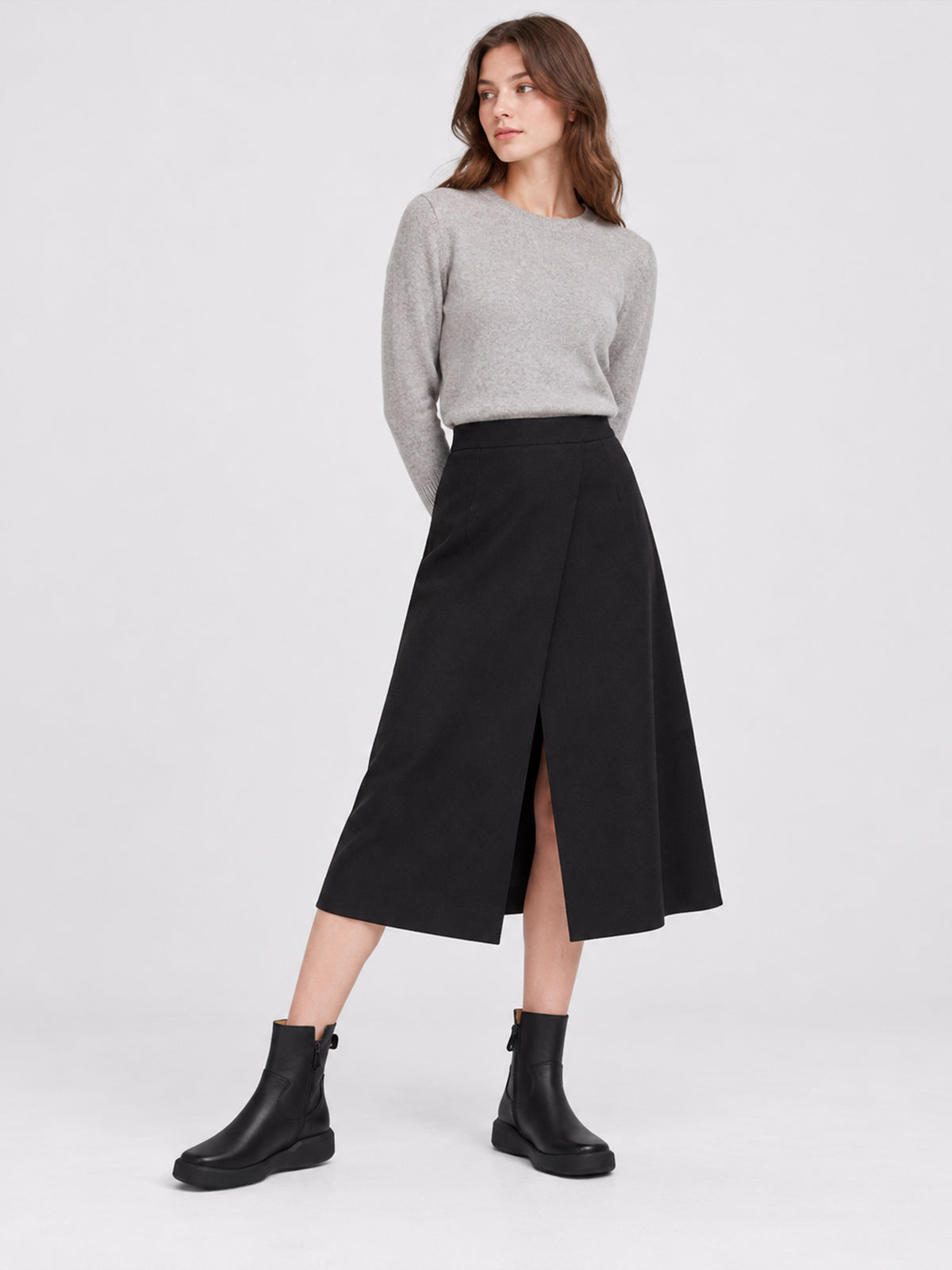 Black zip ankle boots, worn with a grey top and black skirt.