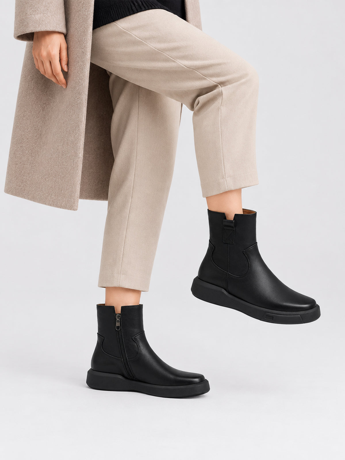 Black zip ankle boots, close-up of the shoes being worn.