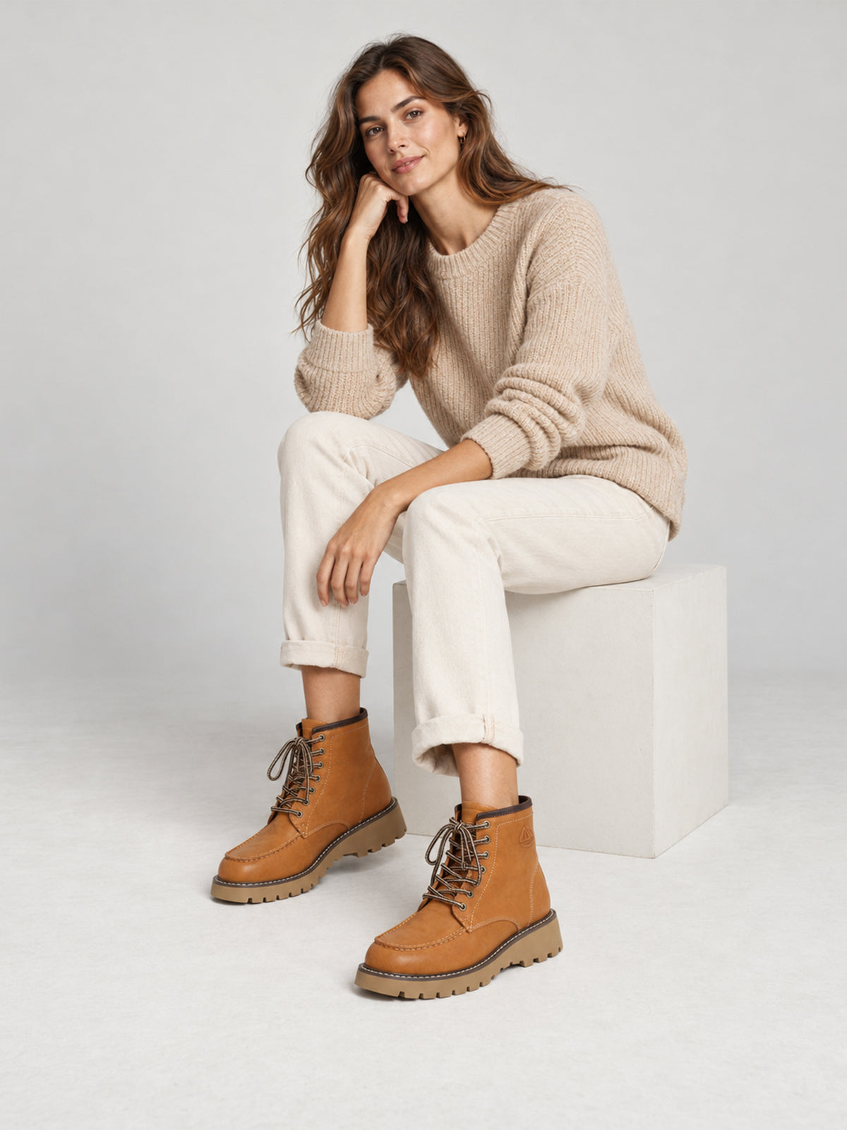 Tan washed leather combat boots, worn in a seated outfit.
