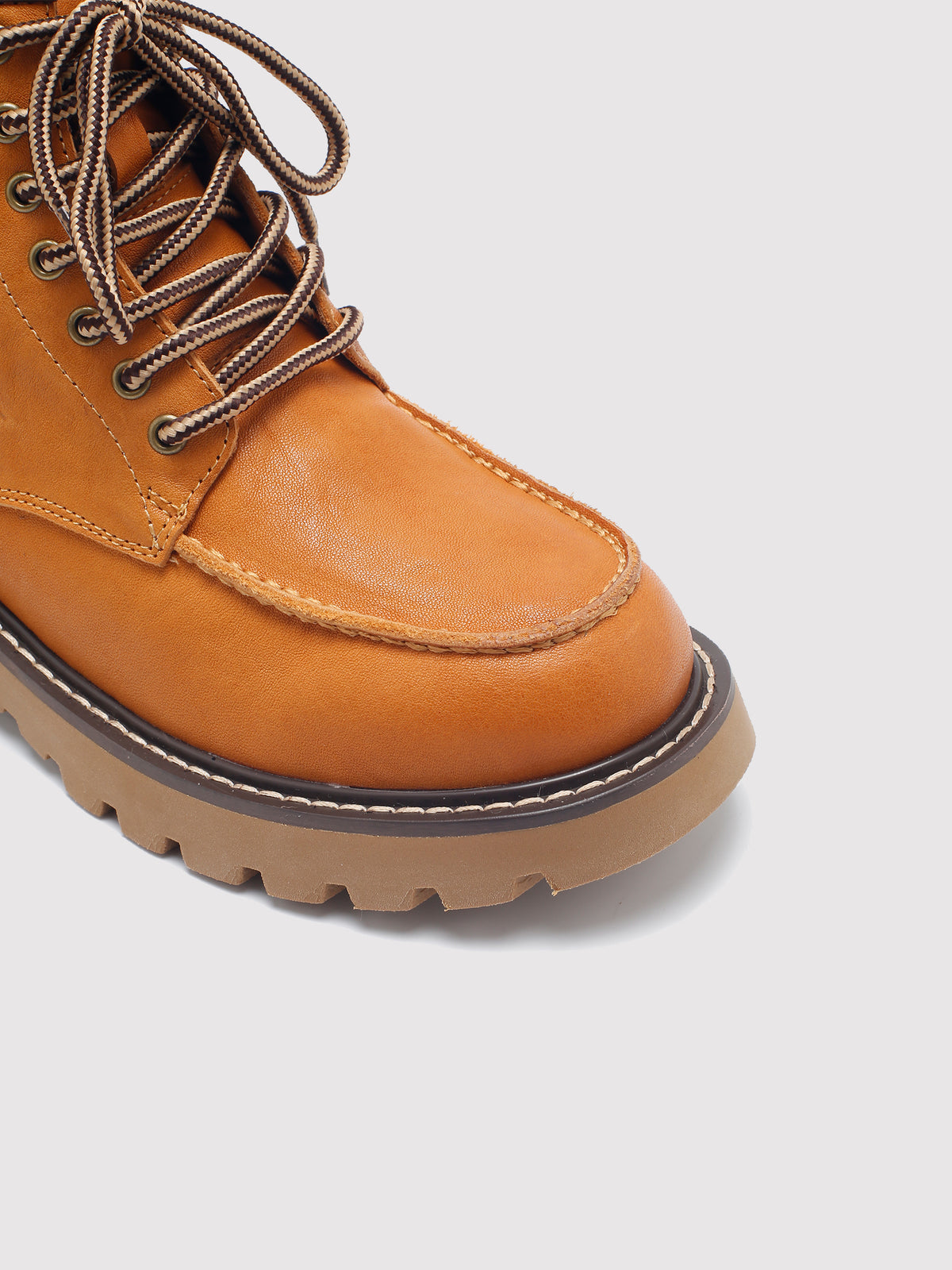 Tan washed leather combat boots, close-up of the toe and sole edge.