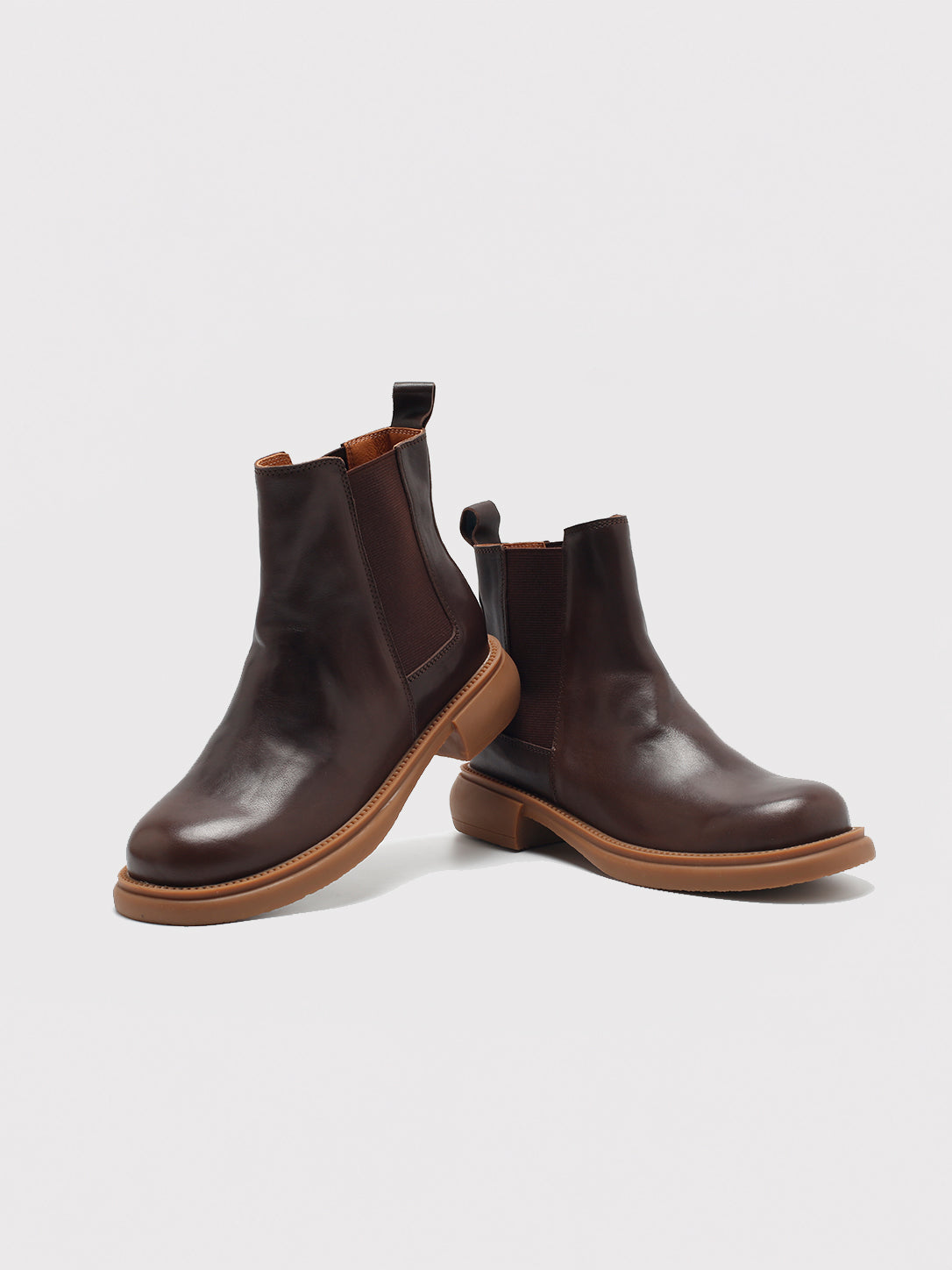 Dark brown washed-leather Chelsea boots, pair arranged at different angles.