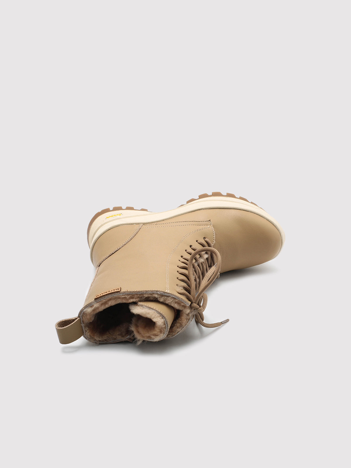 Beige Aspen shearling lace-up boots, boot lying on its side with the opening visible.