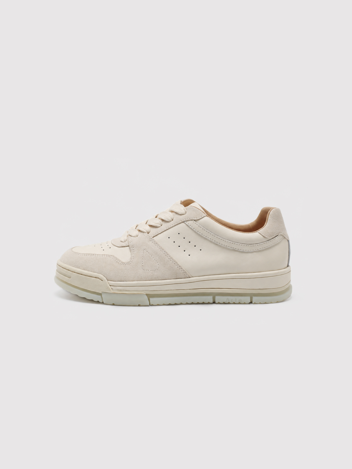 Side view of a cream low-top sneaker with perforated panels.