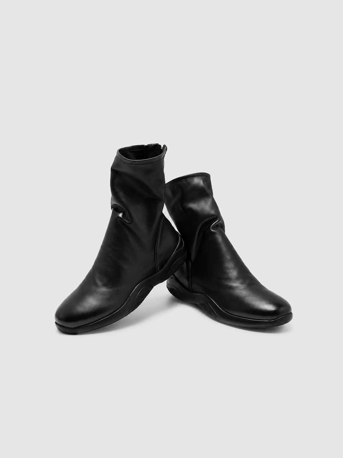 Black lambskin sock boots, pair arranged at different angles.