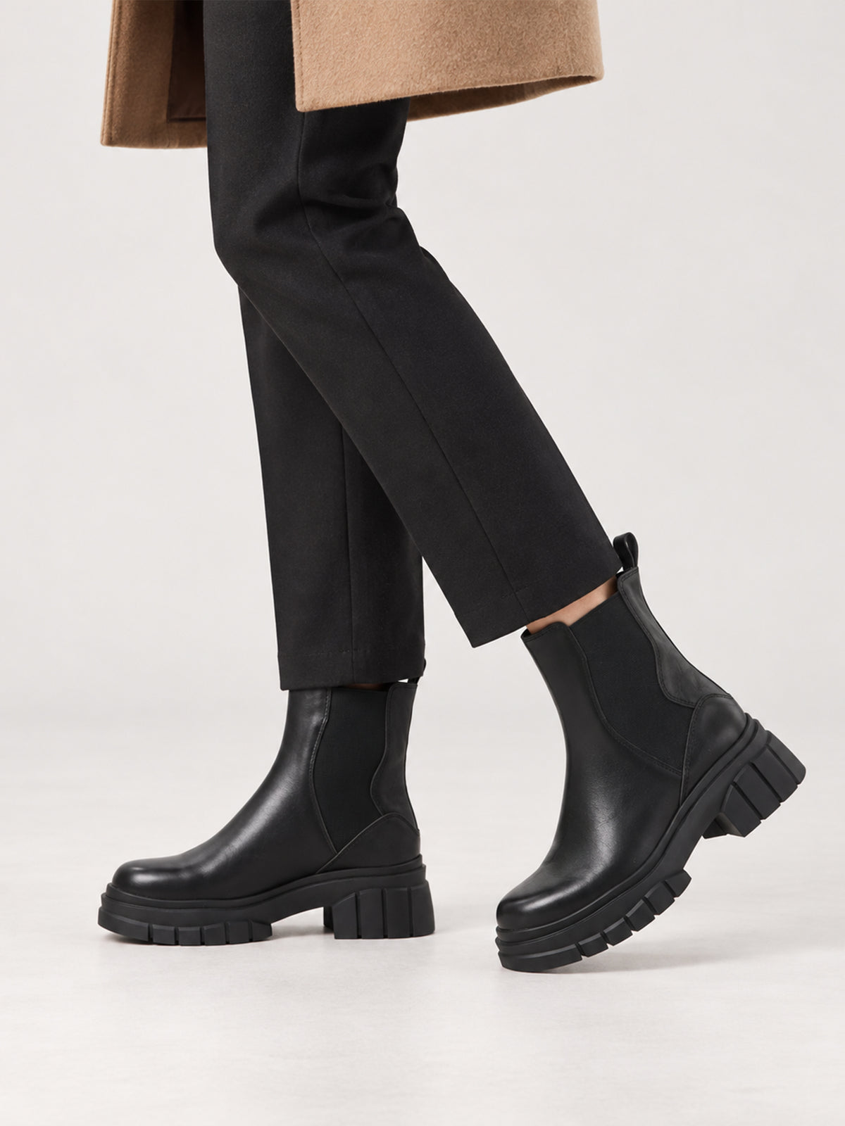 Black shaft boots with lug soles, close-up of the shoes being worn.