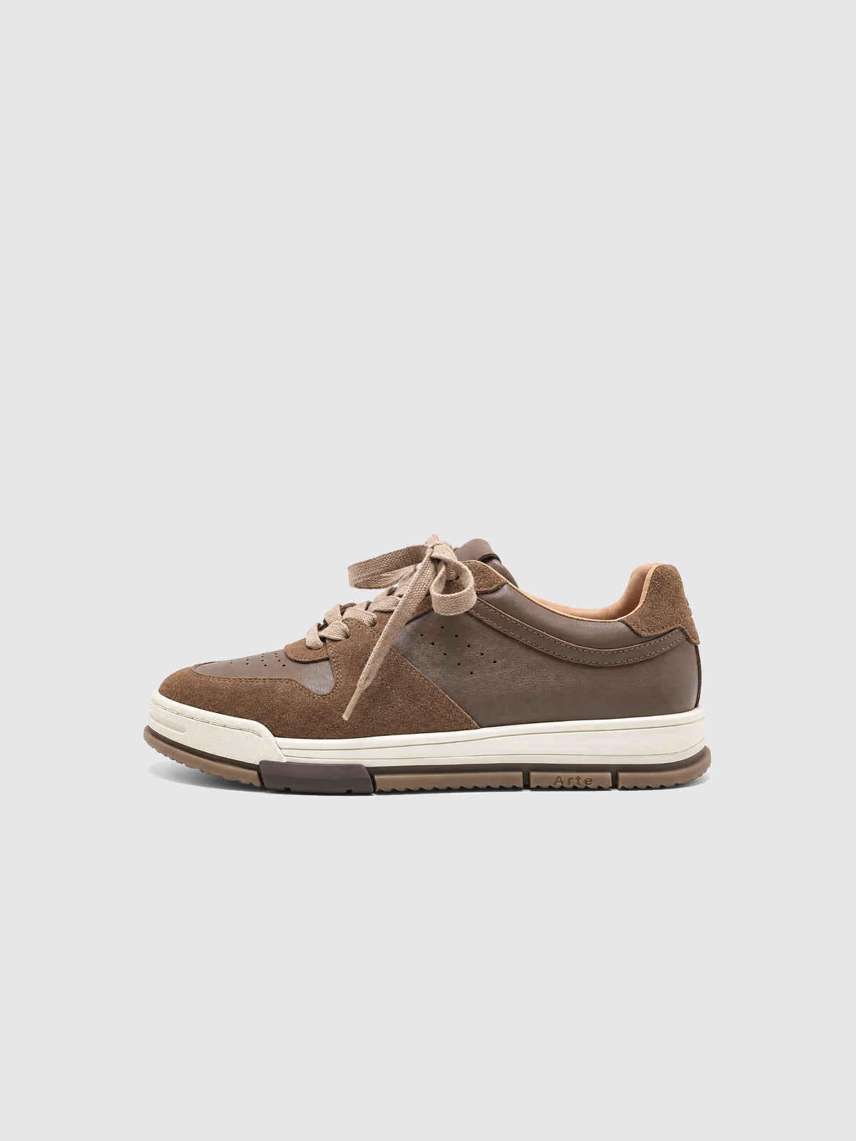 Side view of a brown low-top sneaker with a cream sole.