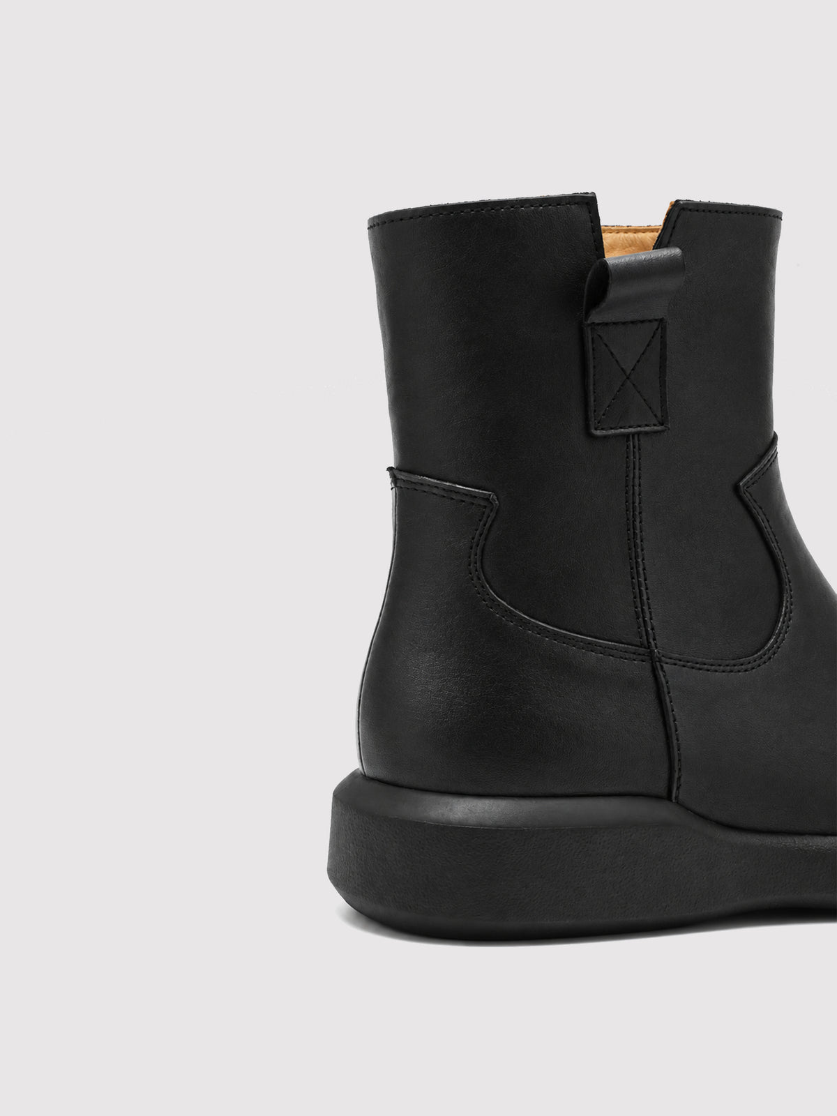 Black zip ankle boots, close-up of the heel and rear upper.