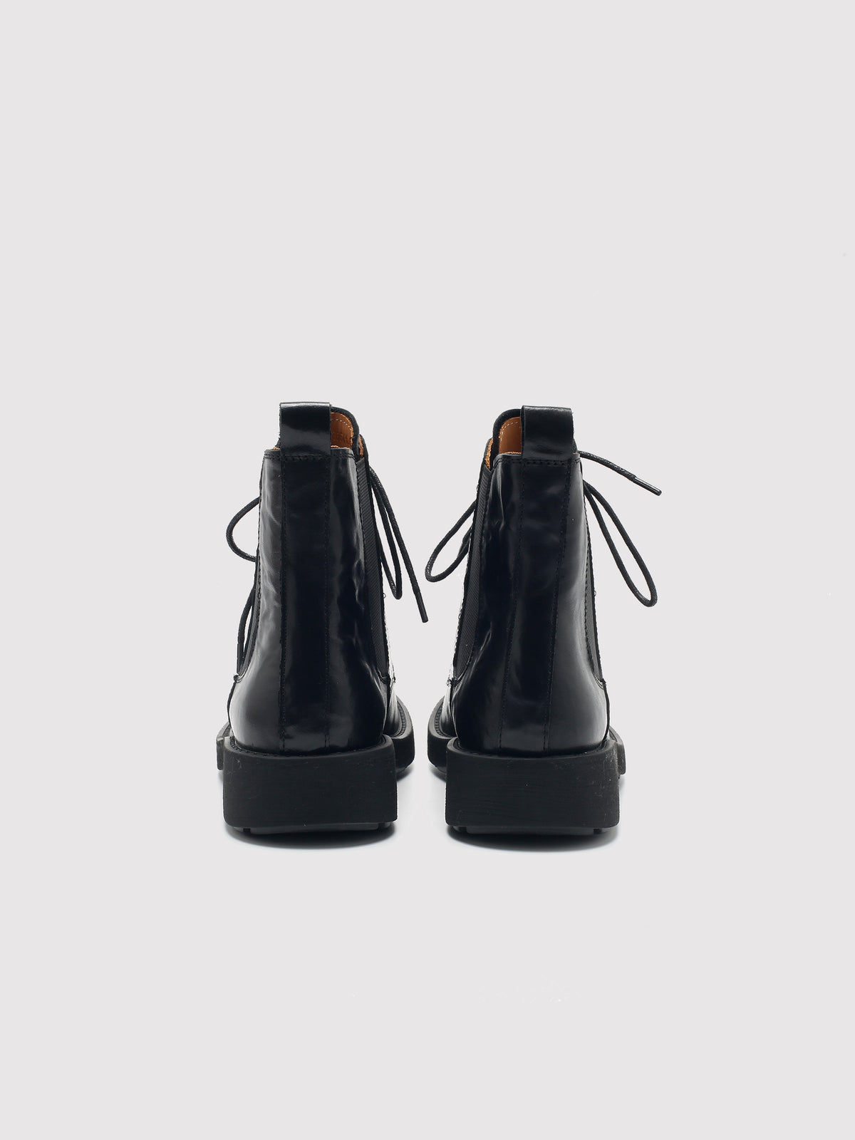 Vegetable-tanned black lace-up boots, pair viewed from the back.
