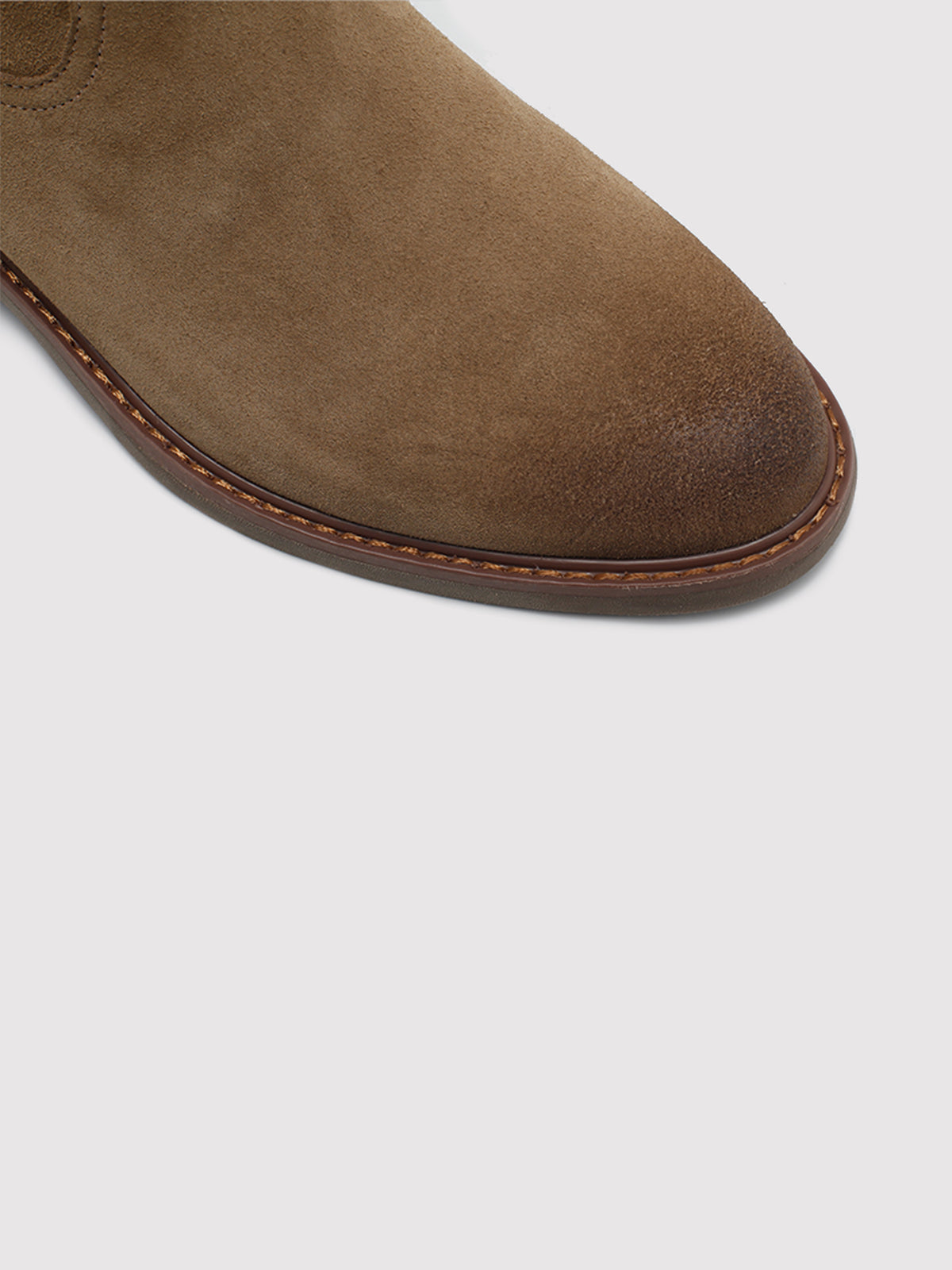 Tan pointed-toe boots, close-up of the toe and sole edge.